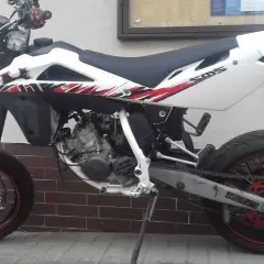 Husqvarna SM 125 z czerwono-czarnymi grafikami. Dane techniczne tego zwinnego supermoto są imponujące.