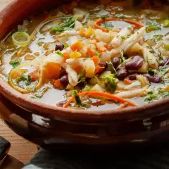 Herzhaftes Minestrone Rezept in einer rustikalen Tonschüssel, gefüllt mit Gemüse, Bohnen und Nudeln.