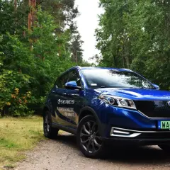 Niebieski SUV Seres 3 na leśnej drodze.
