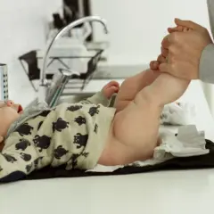 En bebis med björnmönstrad tröja byter blöja. Förhoppningsvis behövs inget medicin mot diarré idag.
