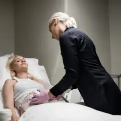 En kvinna får behandling för coolsculpting armar. En terapeut applicerar apparaten på hennes överarm.
