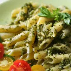Makaron penne z pesto i świeżą bazylią, podany z pomidorkami koktajlowymi. Idealny sycący obiad bez mięsa.