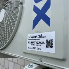 Zewnętrzna jednostka klimatyzacyjna z naklejką firmy MWinstal.com.