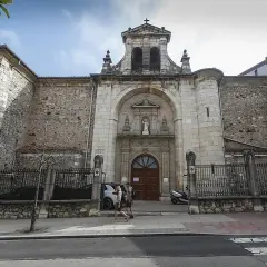 Fachada de la iglesia Consolación en Santander, con una pareja paseando por la acera.