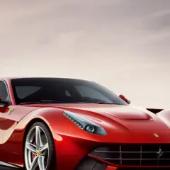 Czerwone Ferrari F12 Berlinetta lśni w słońcu, gotowe do jazdy.