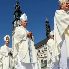 Biskupi w białych szatach procesyjnie idą pod jasnobłękitnym niebem. W tle widać wieże klasztoru, gdzie niedawno podpisano ważny konkordat.