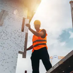 Operaio installa pannelli per cappotto termico esterno su un piano.