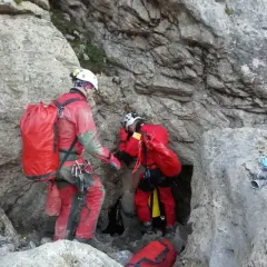 Speleolodzy w czerwonych kombinezonach przygotowują się do eksploracji jaskini, być może najdłuższej jaskini w Polsce.