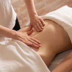Mains douces prodiguant un massage ventre gonflé, apportant détente et soulagement.