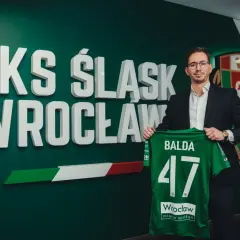 Dyrektor sportowy WKS Śląsk Wrocław, Balda, prezentuje zieloną koszulkę z numerem 47.
