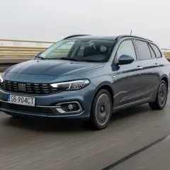 Niebieski Fiat Tipo kombi jedzie po moście. Prawidłowe ciśnienie w oponach zapewnia bezpieczeństwo.