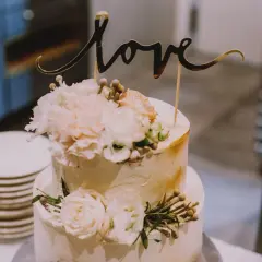 Elegancki tort weselny z napisem "love" i kwiatami. Wyobraź sobie jego pyszne tort weselny smaki!