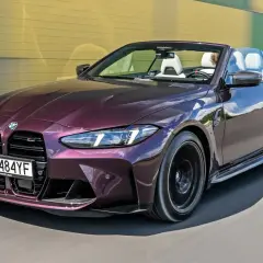 Fioletowe BMW M4 Cabrio na drodze. Zastanawiasz się, ile kosztuje BMW M4? Ten model to marzenie wielu kierowców.