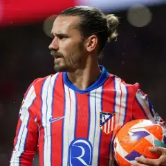 Antoine Griezmann w koszulce Atletico Madryt trzyma piłkę.
