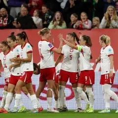 Piłkarki w biało-czerwonych strojach świętują sukces. To dumne polskie dania na boisku, pełne radości i sportowego ducha.