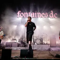 Fontaines D.C. live in Stuttgart, mit Sänger im Scheinwerferlicht und Band auf der Bühne.