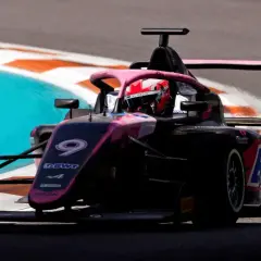 Kobieta w bolidzie F1 z numerem 9 na torze.