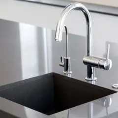 Nowoczesny zlew z kamienia naturalnego, z chromowaną baterią i dodatkowym kranikiem.