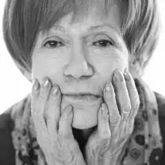 Portret Marii Czubaszek, z dłońmi podpartymi na policzkach. Jej spojrzenie przywodzi na myśl jej słynne maria czubaszek cytaty.