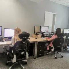 Trzy kobiety pracujące przy komputerach w biurze.