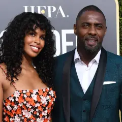 Idris Elba z żoną, Sabriną Dhowre, na czerwonym dywanie. Ona w kwiecistej sukience, on w eleganckim garniturze.