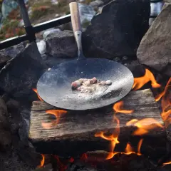 Kolbulle smet fräser i stekpannan över öppen eld. En klassisk fjällmåltid tar form.