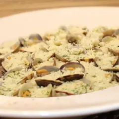 Delicioso arroz con almejas, un plato de marisco cremoso y lleno de sabor, adornado con perejil fresco.