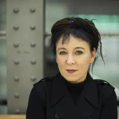 Olga Tokarczuk, laureatka Nagrody Nobla, w czarnym płaszczu. Jej życiorys to fascynująca podróż przez świat literatury.