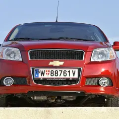 Czerwony samochód Chevrolet z austriacką tablicą rejestracyjną 15-W 88761 V.
