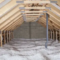Charpente de grenier avec isolation en laine de verre soufflée, prête pour une déchetterie ou une rénovation.