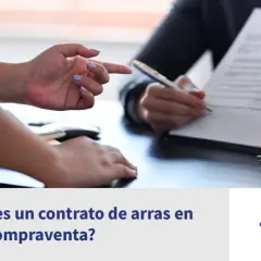 Manos firmando un contrato de arras confirmatorias, con llaves y maqueta de casa.