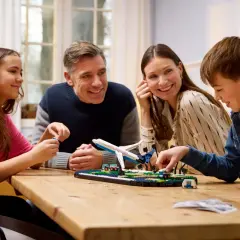 Familie baut gemeinsam ein Flugzeugmodell. Die Faszination LEGO verbindet Jung und Alt.