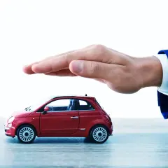 Ręka chroni czerwony model samochodu. Szybkie cepik sprawdzenie oc to podstawa bezpiecznej podróży.