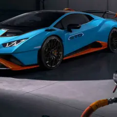 Niebieskie Lamborghini Huracán STO z pomarańczowymi akcentami w garażu.
