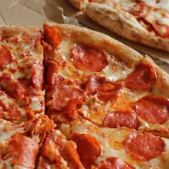 Deux pizzas au pepperoni, une avec une pâte à pizza croustillante bien dorée, garnie de fromage fondant et de rondelles de pepperoni.