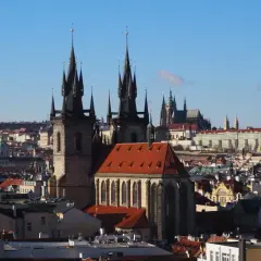 Gotycka wieża w Pradze góruje nad miastem, a w tle widać zamek.