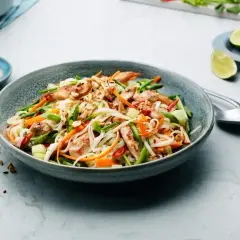 En läcker asiatisk sallad med nudlar, kyckling, grönsaker och jordnötter. Serveras med en krämig dressing och limeklyftor.