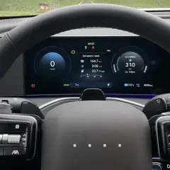Wnętrze samochodu elektrycznego marki Hyundai. Na ekranie widoczny zasięg 310 km, zużycie energii i inne dane.
