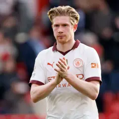 Kevin De Bruyne, w białej koszulce Manchesteru City, klaszcze w dłonie. Jego obecne drużyny to Manchester City.