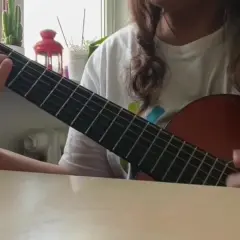 Osoba gra na gitarze klasycznej, ćwicząc znane utwory na gitarę klasyczną.