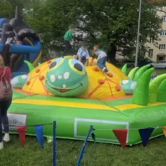 Dzieci bawią się na dmuchanej gąsienicy, jednej z wielu atrakcji na dzień dziecka.