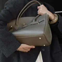 Elegancka, szara torebka na ramię z uchwytami i złotymi elementami. Idealnie wpisuje się w trendy, pokazując, jakie torebki są teraz modne.