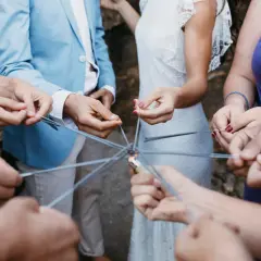 Manos sostienen bengalas formando un círculo, creando un ambiente festivo para juegos para bodas.