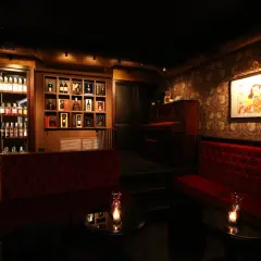 Atmosfera elegante con divani rossi, pianoforte e scaffali pieni di bottiglie. Un locale che potrebbe essere tra i migliori club di Napoli.
