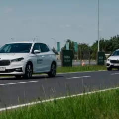 Białe Skody na torze szkoleniowym, jedna próbuje wyprzedzanie drugiej.