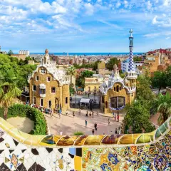 Kolorowa mozaika wita podczas zwiedzania Parku Güell. W tle bajkowe domki i panorama Barcelony.