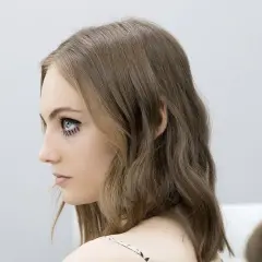 Chica con media melena escalada y maquillaje dramático en los ojos.