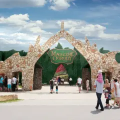 Kamienna brama "Magiczne Ogrody" zaprasza na niezapomniane atrakcje dla młodzieży. Rodziny wchodzą do bajkowego świata.