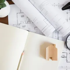 Uproszczony wypis z rejestru gruntów, plany architektoniczne, lupa i drewniany domek.