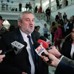 Mężczyzna z siwą brodą, przypominający ojca Agnieszki Pomaskiej, udziela wywiadu dziennikarzom.